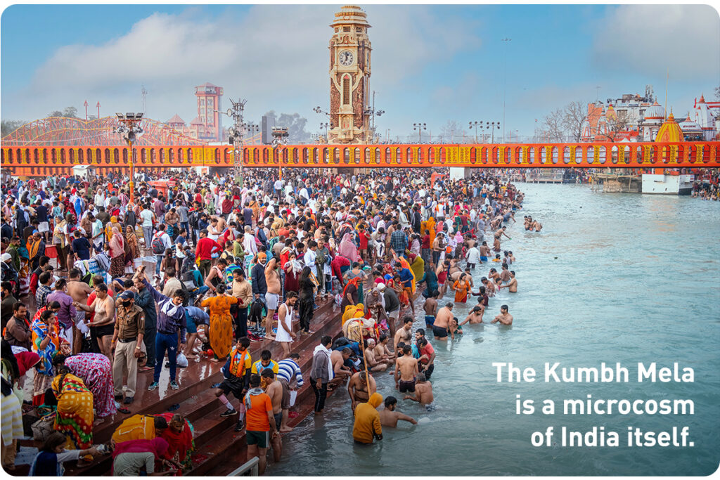 Colorful photo of religious gathering, with hundreds of people bathing on the river.